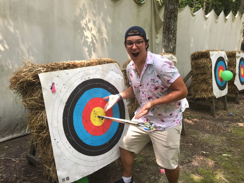 A Wcrc Camper Proudly Showing Off His Successful Bullseye Archery Shot.