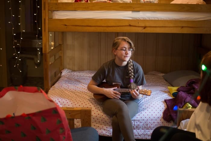 Winter Youth Retreat 2024 7 A Girl Playing A Ukelele In One Of The Cabins Used For Winter Retreats At Wcrc In Williamsburg, Virgninia