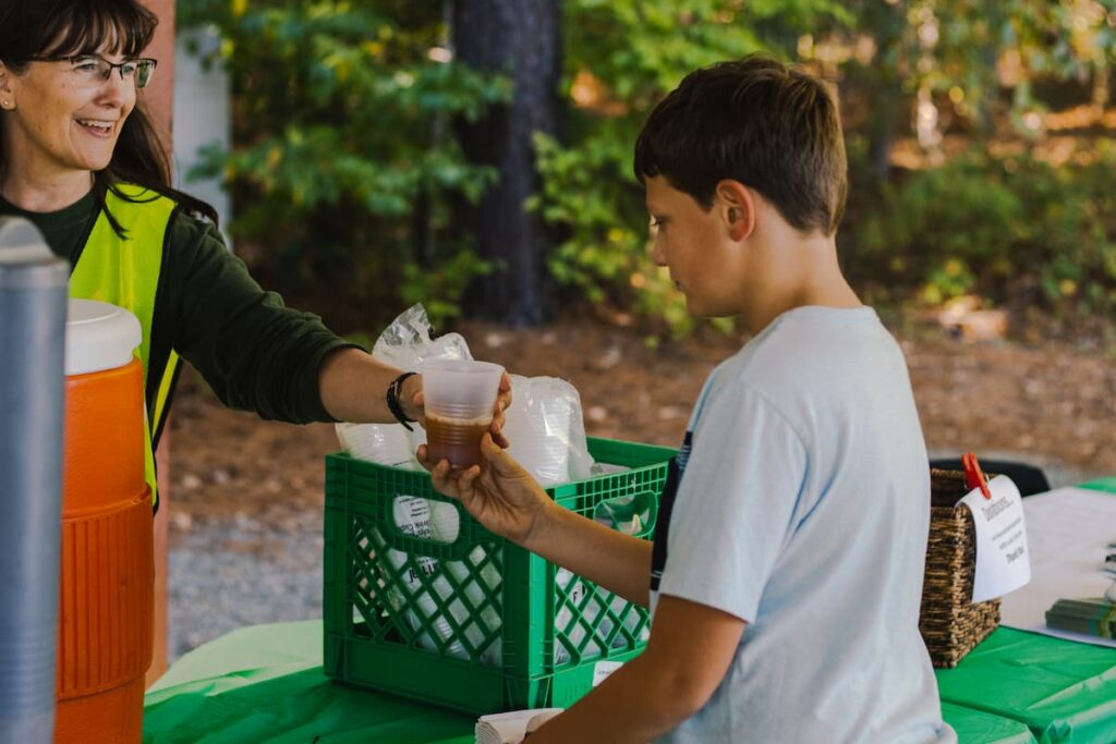 A Staff Member Serving A Boy A Cup Of Soda At Wcrc&Quot;S Family Harvest Festival