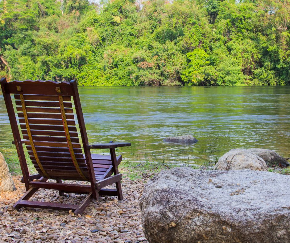 Empty Chair By A Peaceful Lake, Symbolizing Solitude And Rest During Respite Retreats